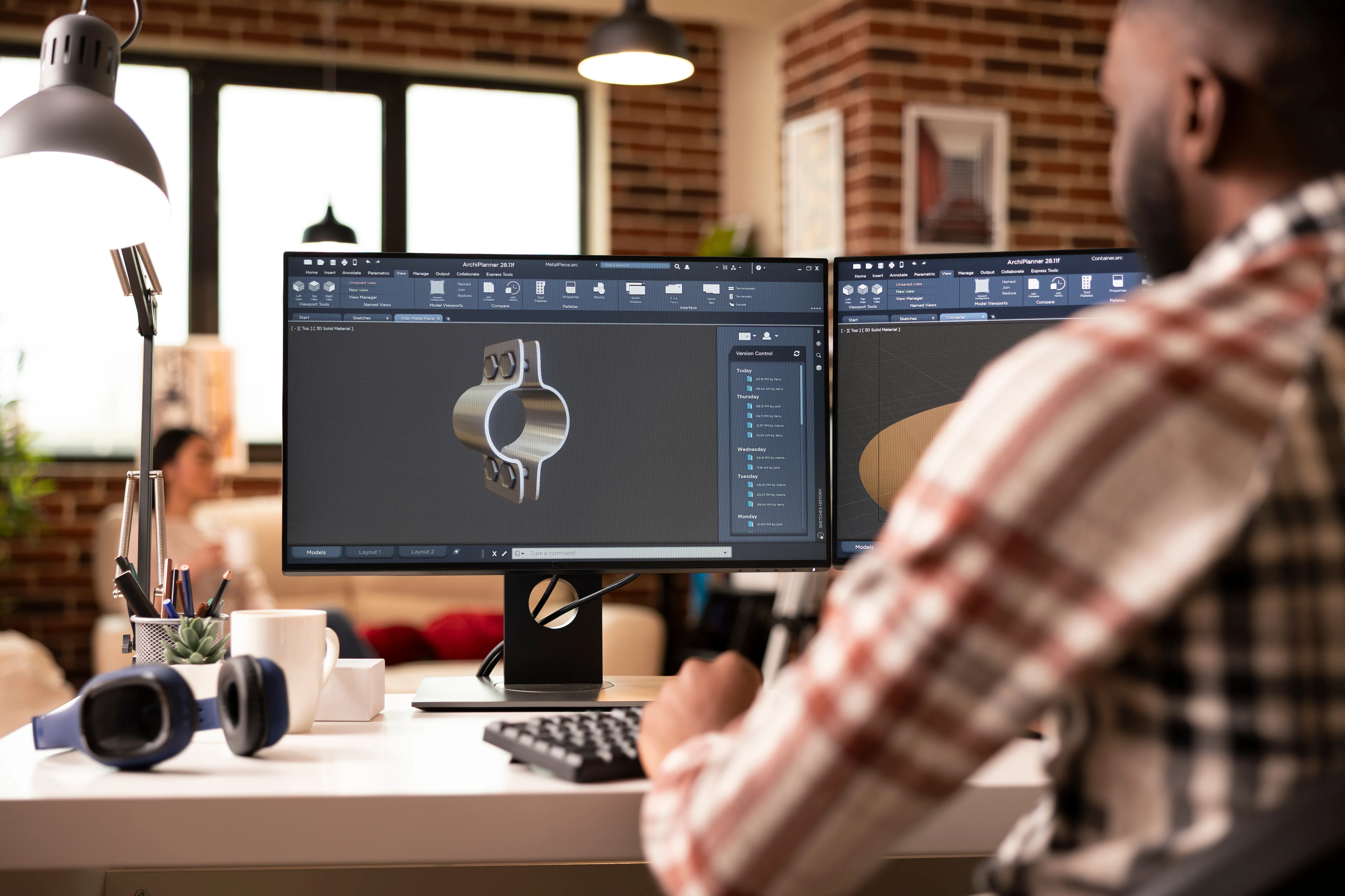 Engineer working on a 3D CAD model at a dual-monitor workstation